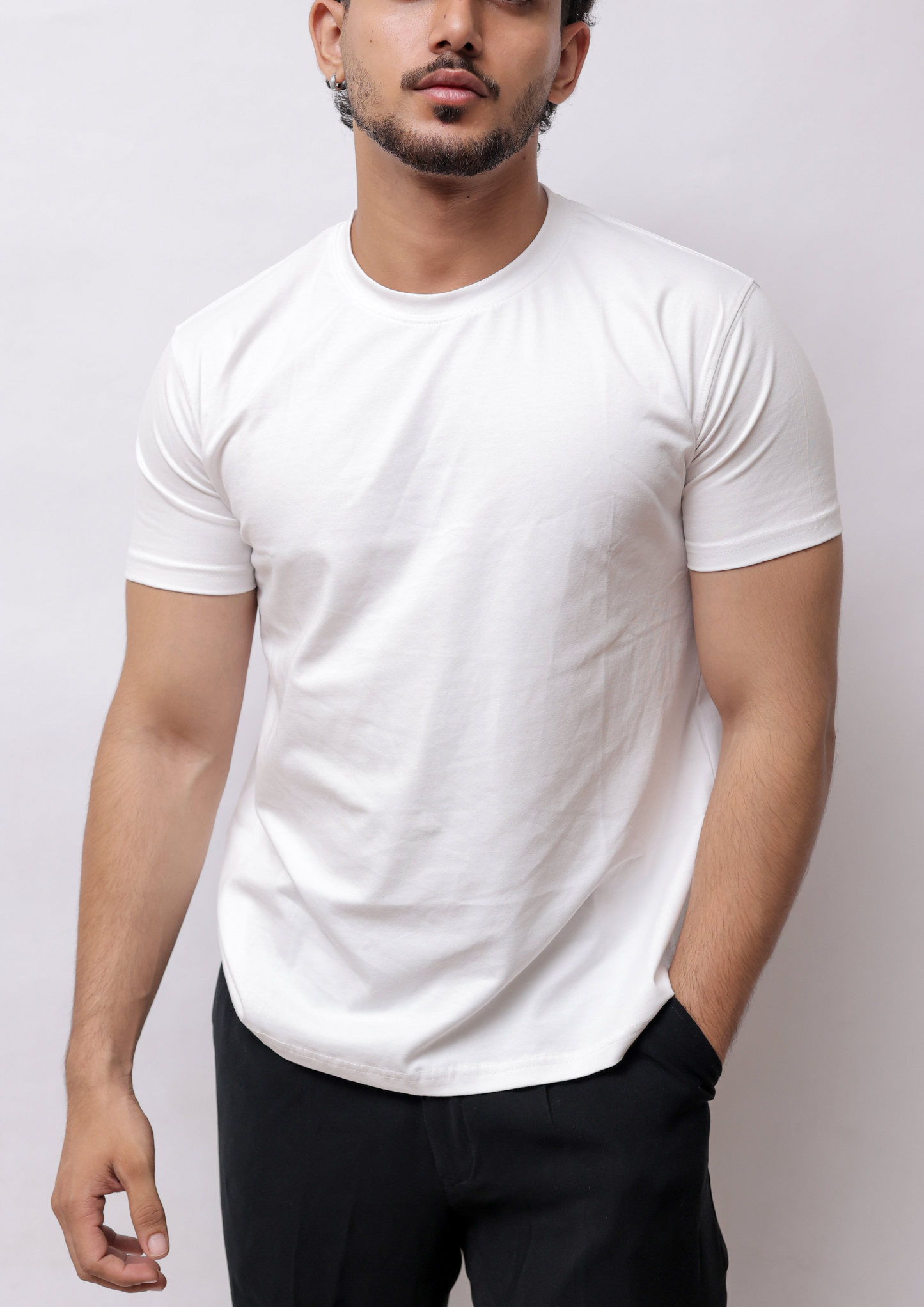 A man wearing a white short-sleeve crewneck t-shirt and black pants, shown from a high-angle side profile against a plain light gray background.